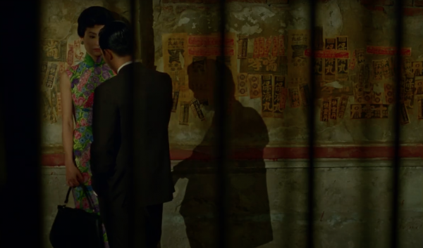 Well dressed man and woman from Hong Kong stand opposite each other on the street at night