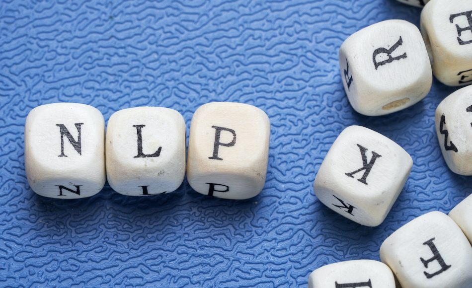 Word nlp neuro linguistic programming on a wooden cubes on a blue background