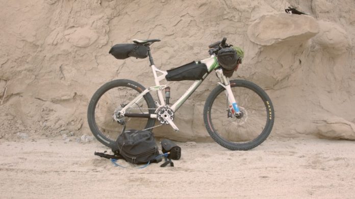 white mountain bike leaning up against rock formation
