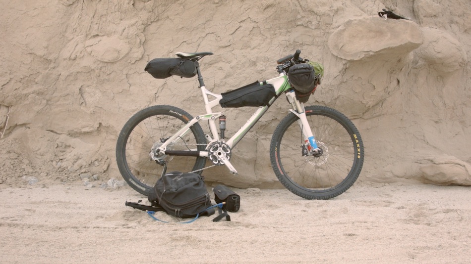 white mountain bike leaning up against rock formation