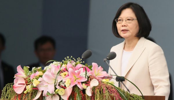 Taiwan’s President Tsai Ing-wen giving a speech at the inaugural ceremony activities in 2016 from a podium covered in flowers.