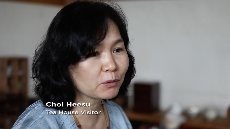 visitor to tea house, woman, black hair, gentle features, light blue top