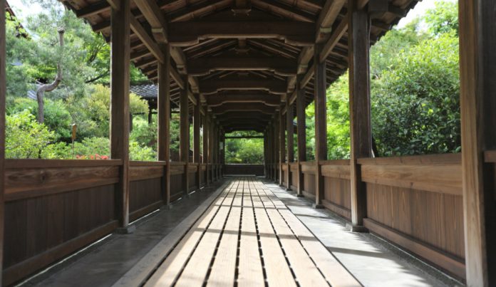 A wooden walkway in a Japanese temple garden in Kyoto.