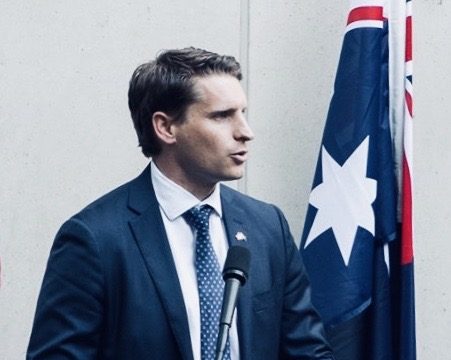 Australian politician, Andrew Hastie, giving a speech from a podium next to the Australian flag.