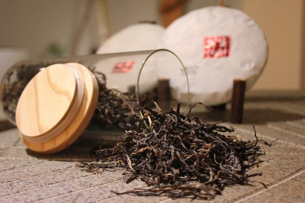 roasted barley tea leaves on table pouring out of opened glass jar with lid