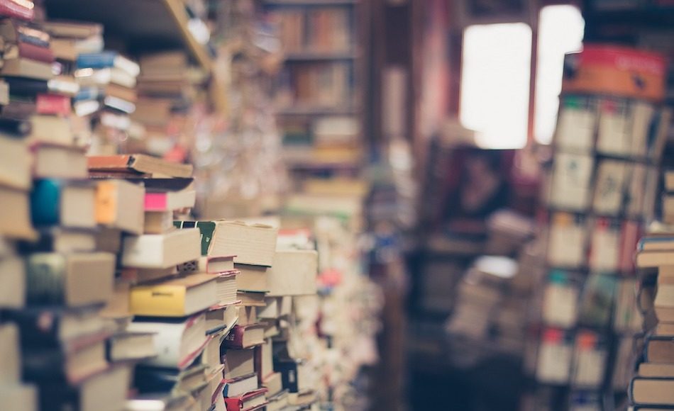 many books piled up which looks like a second hand book store