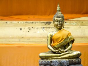 A golden buddha statue with a yellow robe.