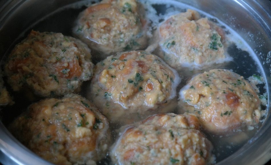 Meatballs and broth in a silver bowl.