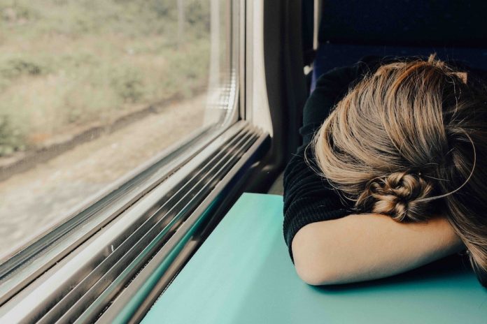 lady resting head on table while travelling on train