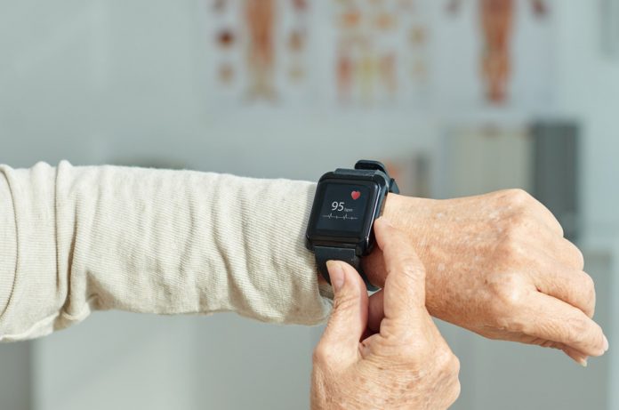 Close up of a fitness tracker showing a woman's heart rate.