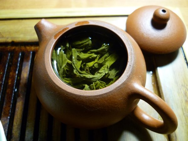 Green tea brewing in a clay pot ready to nourish and hydrate the skin