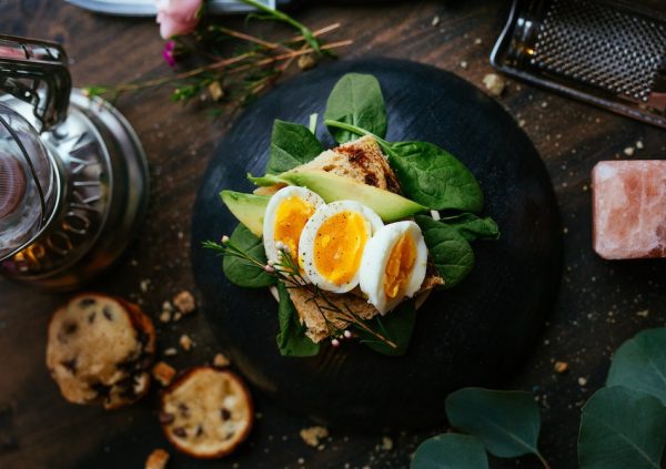 boiled eggs on spinach with avocado and sourdough bread