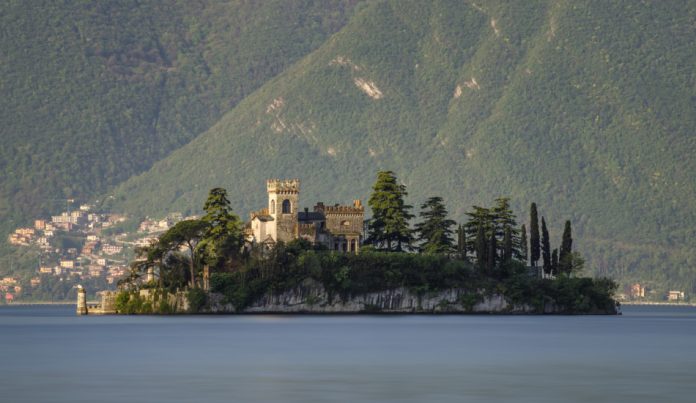 Little island Isola di Loreto on Iseo Lake at sunrise, Italy.