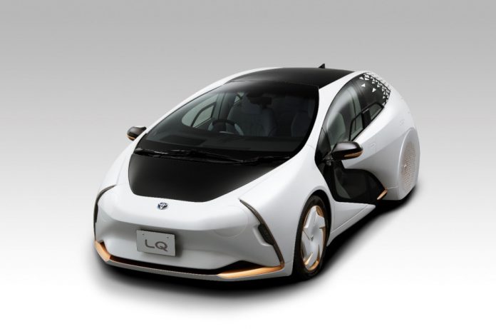 A futuristic looking autonomous vehicle, Toyota's LQ concept car in white with black and gold accents.