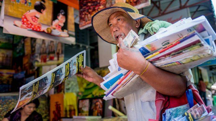 Paper boy Asien Selling news paper