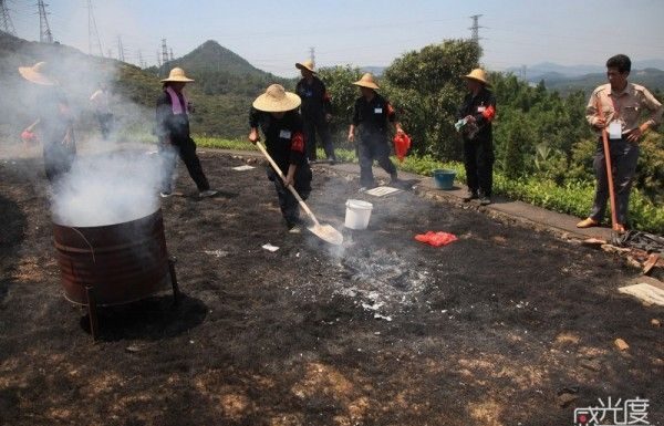 Qingming festival Sanitation workers clean up after a grass fire got out of hand.