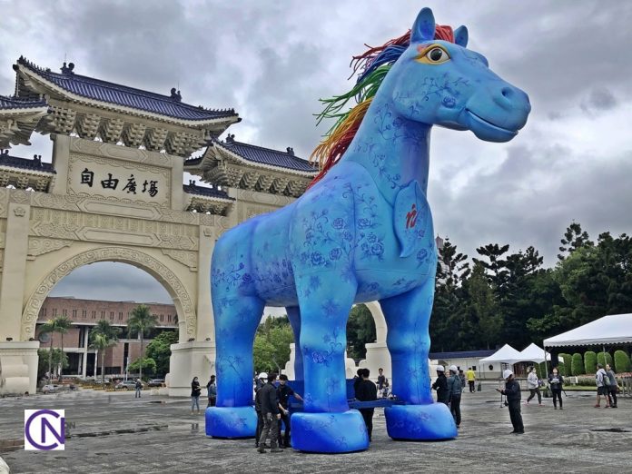 The giant art installation of the Rain Horse is moved from the archway to the center of the plaza for the performance.