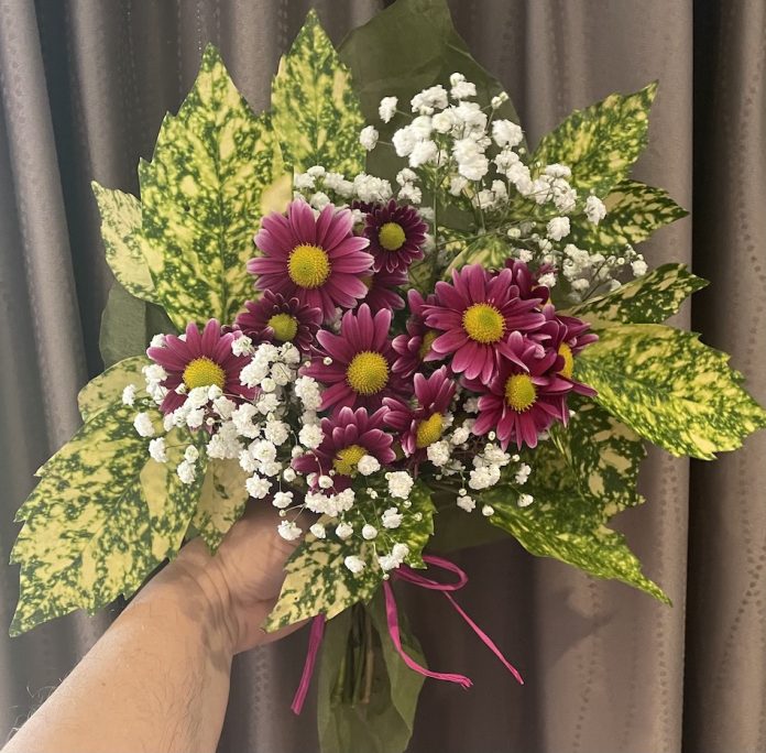 Aucuba Japonica leaves, Baby’s Breath and Pink Chrysanthemums tied together with pink raffia.