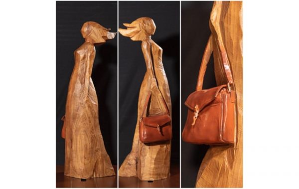 A woman carrying a purse, sculpted out of wood, by Cai Mingfeng.