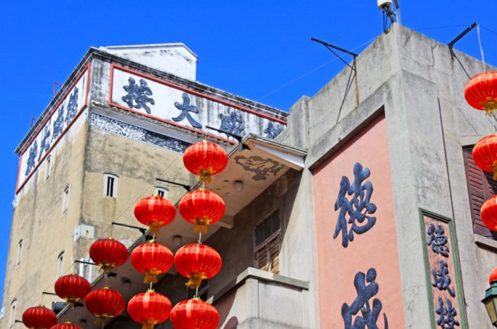 Red Chinese lanterns hang along the side of a building.
