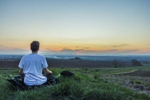 man on mountain meditating