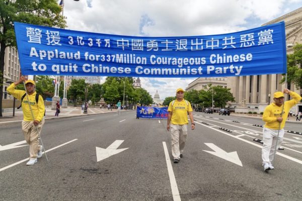 Falun Gong practitioners hold a banner in support of the 330 million Chinese who have withdrawn from the Chinese Communist Party, during a parade in Washington on July 18, 2019.
