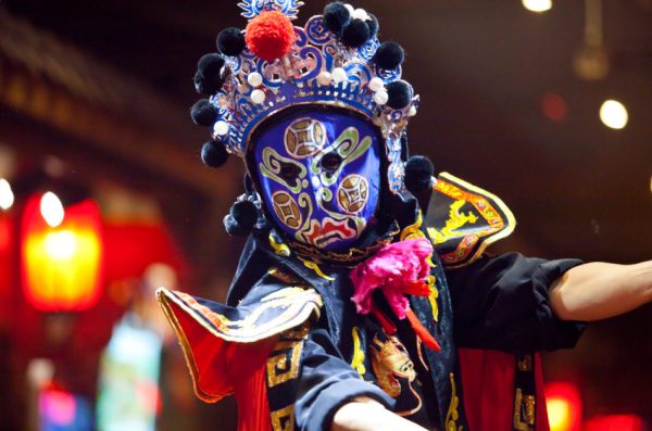 Traditional Chinese opera performance in Sichuan Province, China, with a performer wearing a blue mask.