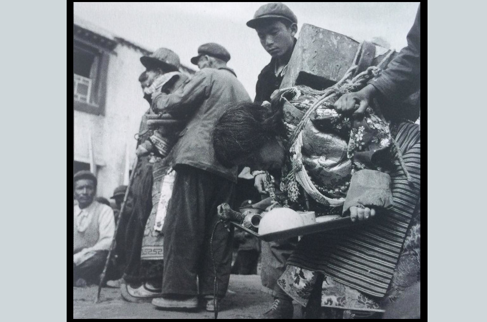 A Tibetan man and his wife being tortured and humiliated in a public struggle session during the Cultural Revolution in China.