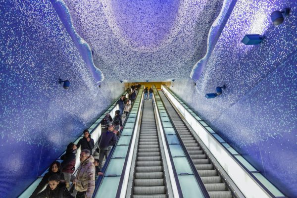 purple roof and walls of Toledo station Naples Italy people are on the escalators