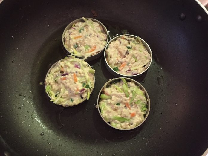 Veggie mixture cooks in rings in frying pan.