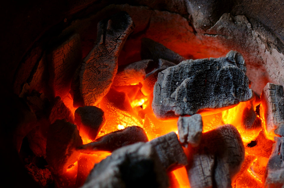 Closeup of charcoal burning in a terracotta kiln.