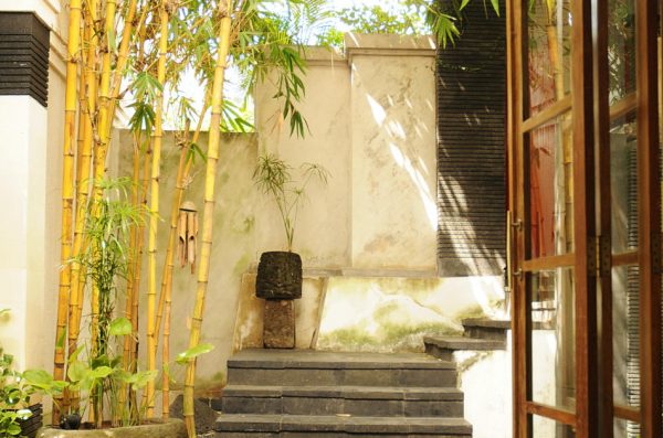 A courtyard with bamboo and wind chimes.
