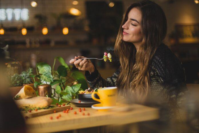 lady eating a meal at a table - eating habits to shift ongoing stress