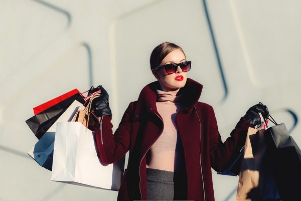 art of wanting less lady with sunglasses and lots of shopping bags
