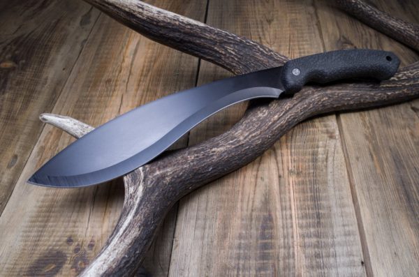 Machete sitting on a wooden surface.