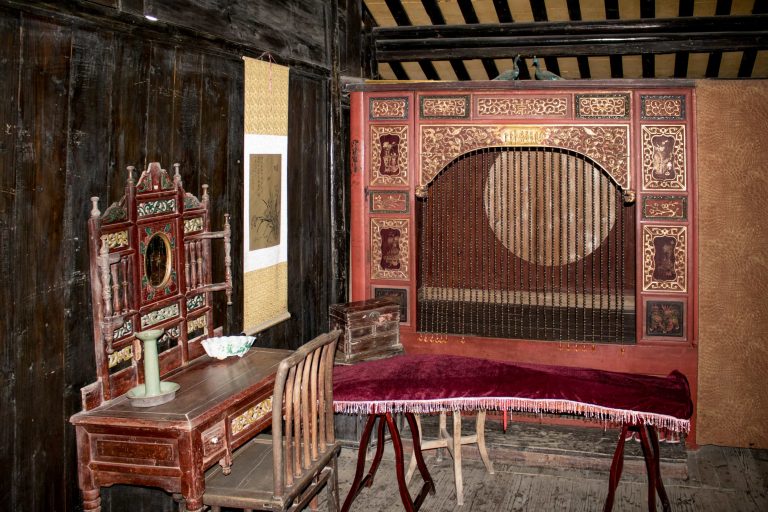 A Chinese bedroom with a bed and desk.