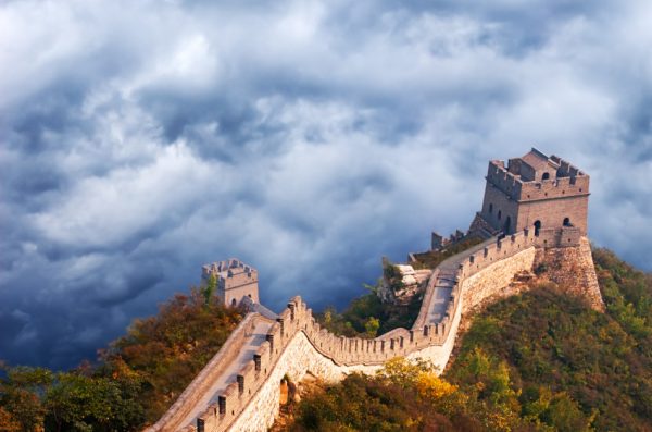 Great Wall of China seen from the air with storm clouds as a backdrop.