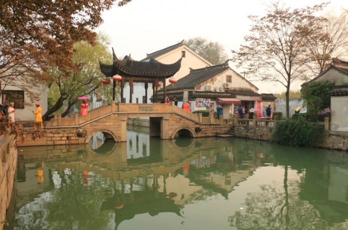 A bridge with Chinese-style pagoda over the waterway in Mudu, China.