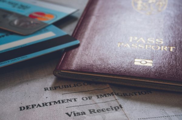 Photo of a passport and credit cards sitting on top of a travel document.