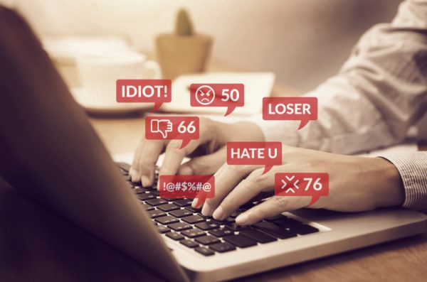 Cyber bullying concept. people using notebook computer laptop for social media interactions with notification icons of hate speech and mean comment in social network.