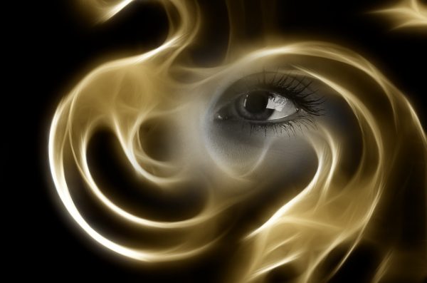 Black and white image of an eye seeing through golden fog.