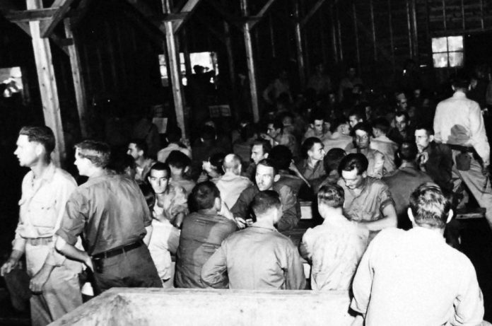 Prisoners of War eating chow at the mess-hall in a WWII Japanese POW camp.