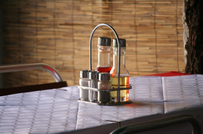 Condiments sitting on a table in a restaurant.