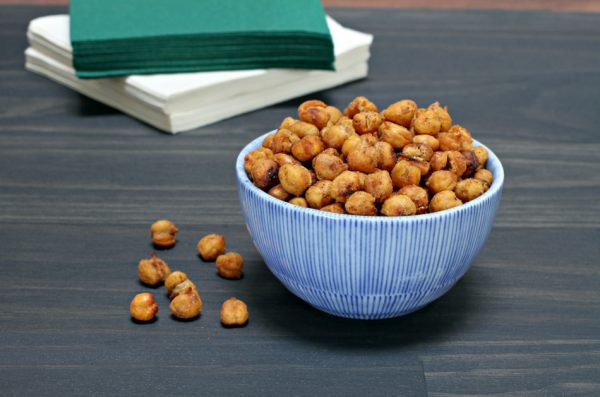 A healthy snack of roasted chick peas in a blue striped bowl.