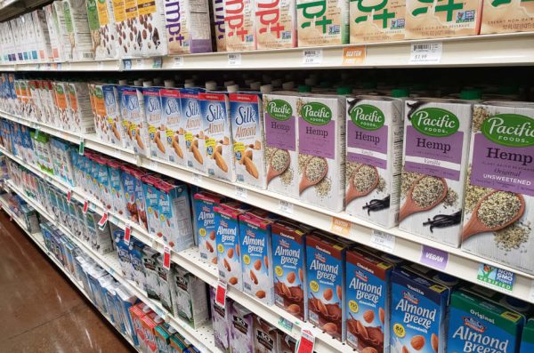 Grocery store aisle containing plant-based milk.