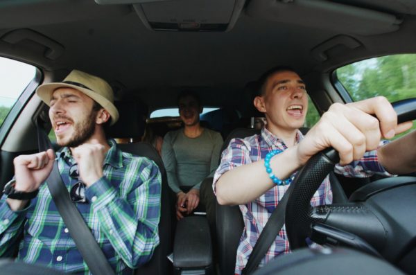 Three people siging in the car.