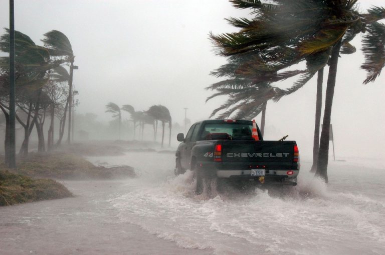 Truck driving through high water in a storm.