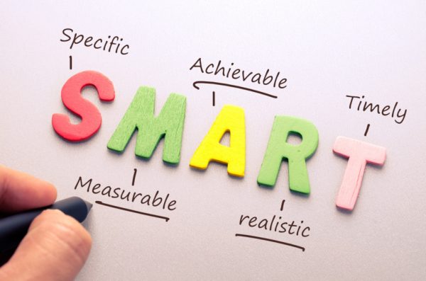 Colorful wooden letters spell "SMART", the acronym for specific, measurable, achievable, realistic, timely goals.