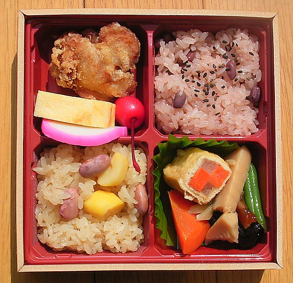 Sekihan (top right) in a bento box with assorted Japanese food.