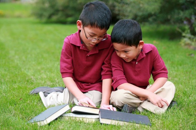 Two Asian boys with four books.